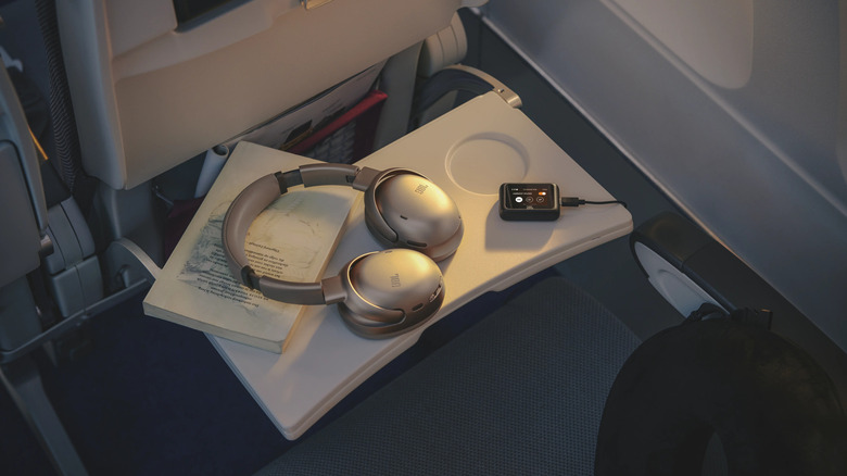 A pair of JBL headphones on an airline seat tray.