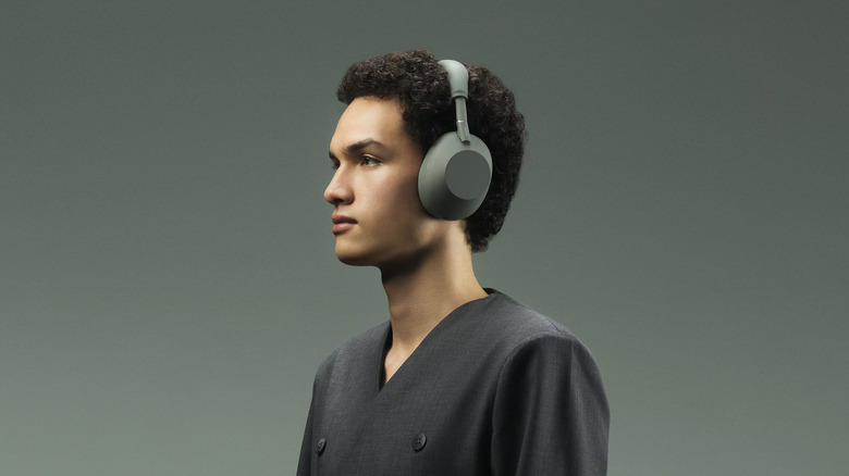 A person stares off into the distance while wearing a pair of Sony headphones.