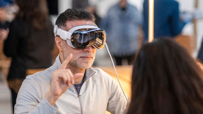 A person using an Apple Vision Pro headset and interacting with virtual controls.