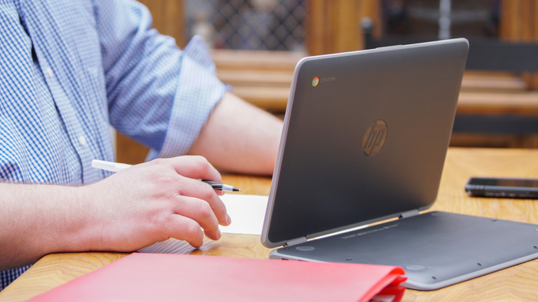 Someone using a Chromebook on a desk unplugged