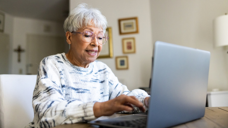 An elderly woman using a laptop