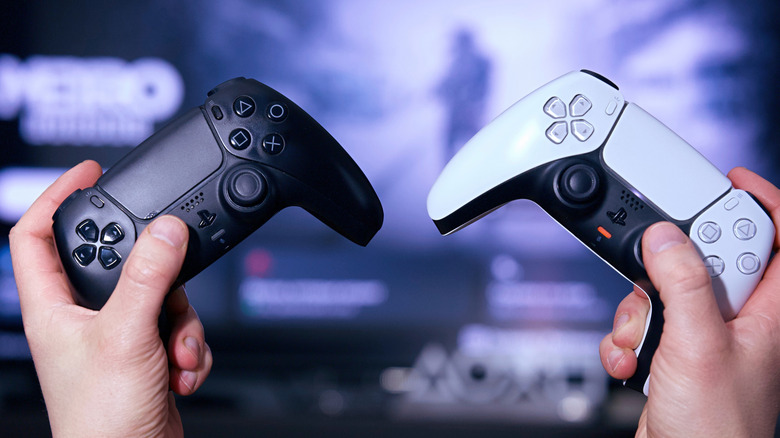 A person holding a PlayStation 5 controller in each hand.