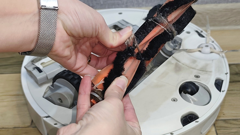 Cleaning the hair off a dirty beater bar brush of a robot vacuum