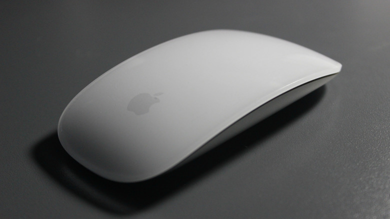 A Magic Mouse casting a shadow on a gray tabletop.