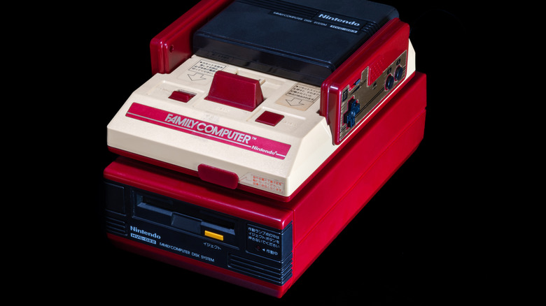 A Famicom sits atop the Disk System.