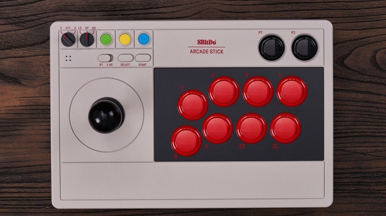 The 8Bitdo Arcade Stick on a wooden surface.