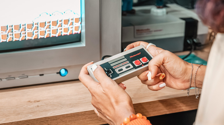 A person playing the Nintendo Entertainment System on an old CRT monitor.