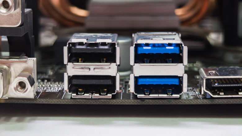A close-up of motherboard rear I/O ports, including standard USB Type-A and blue-colored USB 3.0 ports.
