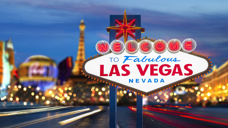 The famous Las Vegas welcome sign with the city blurred in the background.