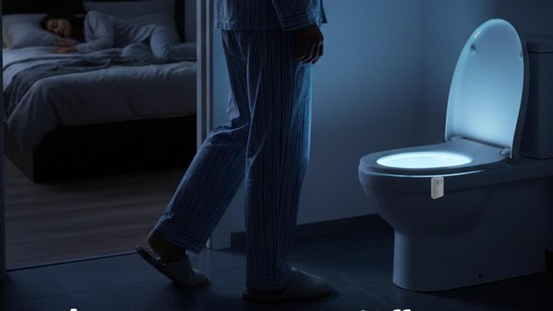 A person in their pajamas walking towards a toilet lit up by the Chunace motion-sensing night light