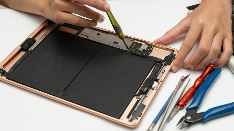 An iPad, with the display removed, being repaired.