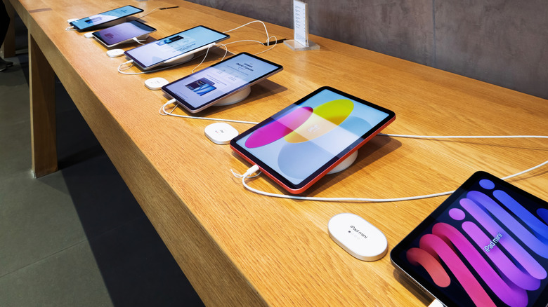 A range of different iPads on a countertop in an Apple store.