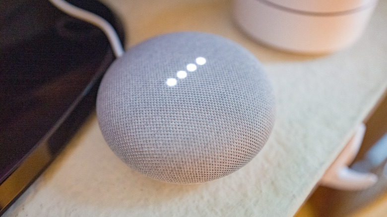 A close up of a Google Home speaker sitting on a desk.
