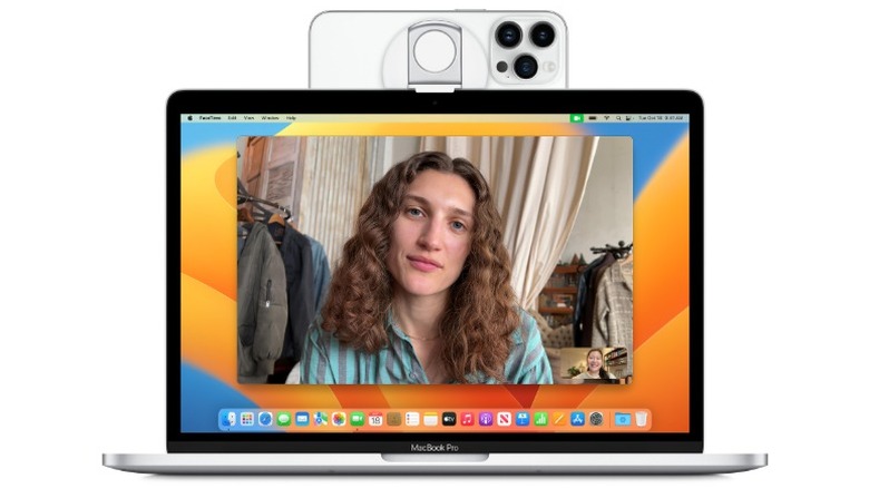 A product render of a MacBook Pro with an iPhone attached to the top of it with a Belkin MagSafe Camera Mount