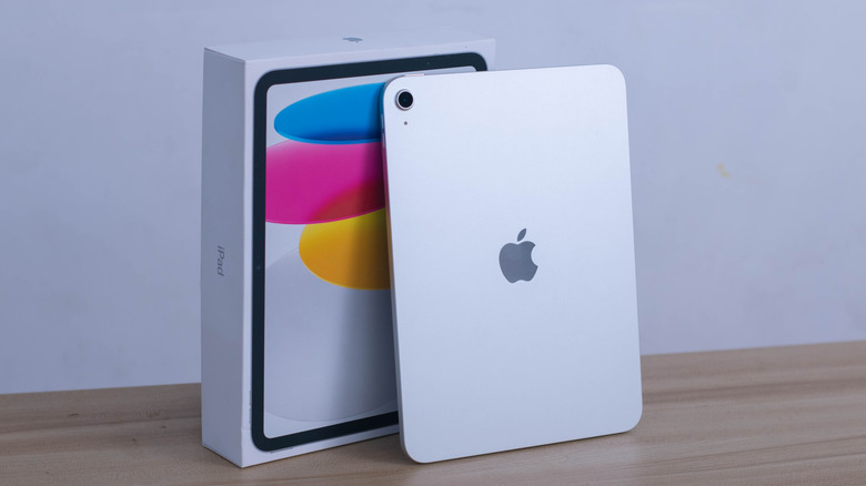 The Apple iPad (11th Gen) with its box on a wooden desk.