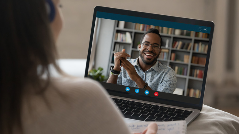 A video call on a laptop, with the person on the screen showing his head and shoulders.
