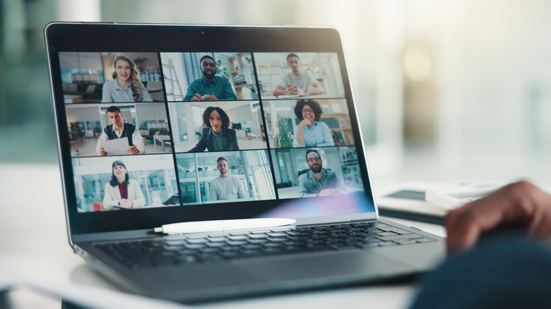 A video call between nine people, shown on a laptop screen.