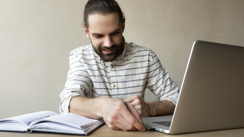 Man putting USB drive in laptop