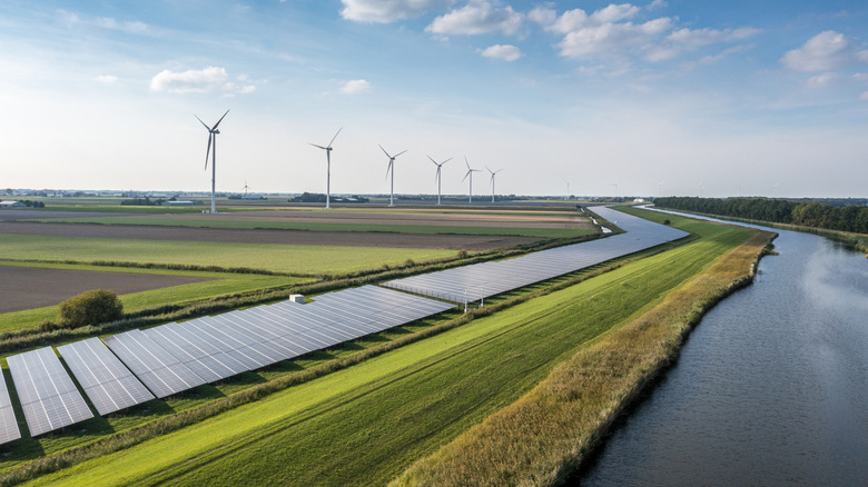 Solar panels and country views with wind turbines in the background.