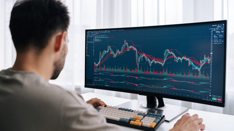 Man a desk using computer with ultra-wide monitor