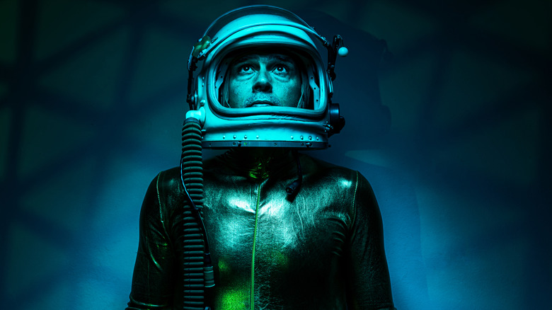 Concept image of a male astronaut in a space suit looking scared