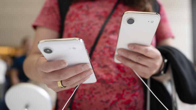 A person interacting with iPhone Air units in a store.