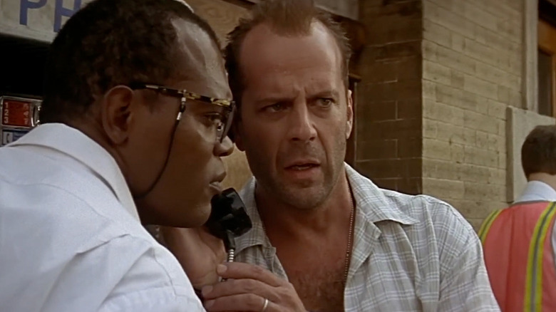 Zeus (Samuel L. Jackson) and John McClane (Bruce Willis) listening to a pay phone on the street in Die Hard with a Vengeance