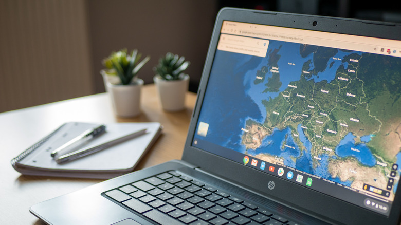 A person using satellite view in Google Maps on a laptop.
