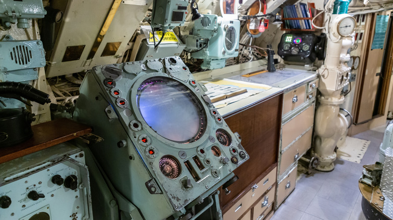 Submarine control room interior showing radar console, navigation equipment, and instrument panels.