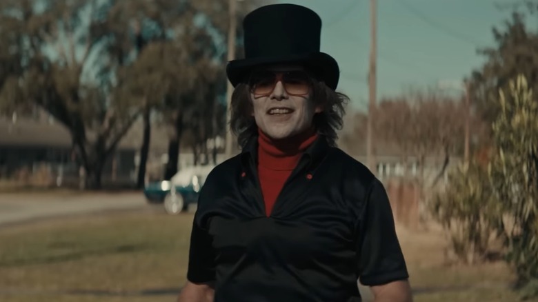 The Grabber wearing a black top hat stood in a street in The Black Phone