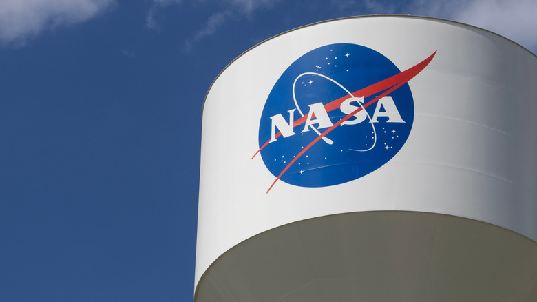 NASA logo on water tower with blue sky in background.