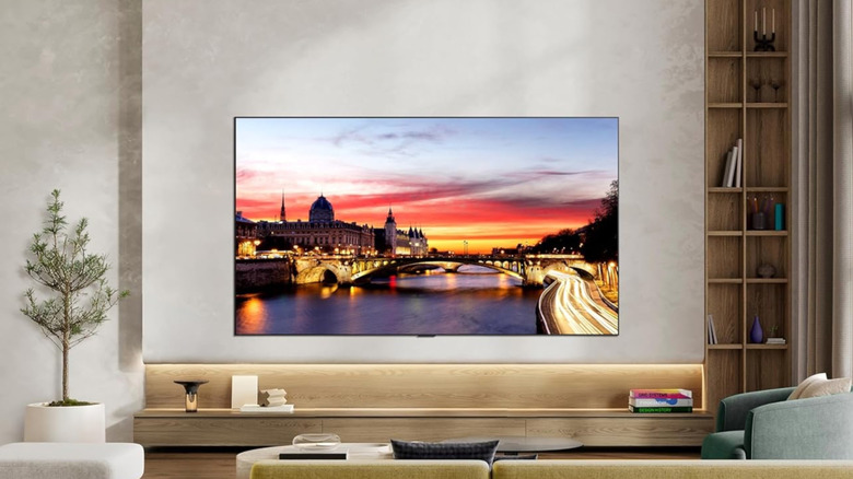 The LG C6 Series OLED wall-mounted in a modern living room above a floor-level shelf.