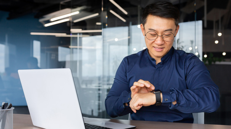 Man using smartwatch at his desk