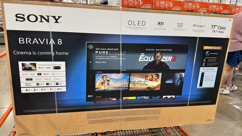 A new Sony Bravia 8 OLED TV on a flatbed shopping cart in a store