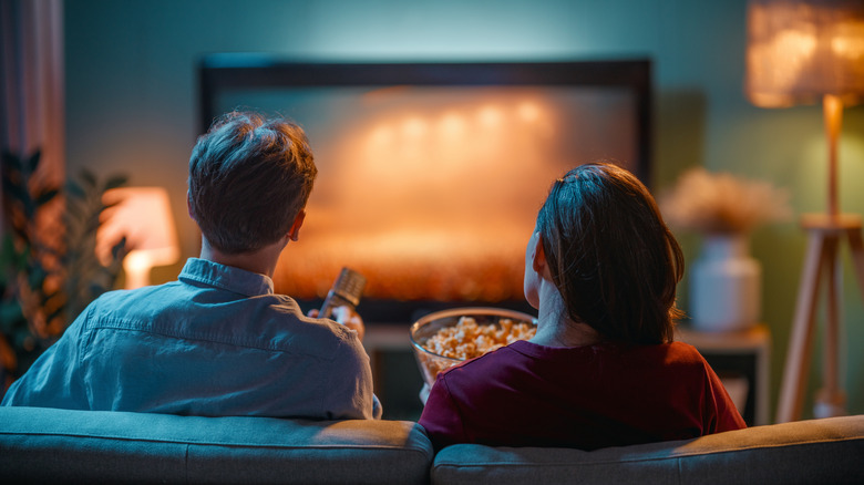 A couple watching a movie from their couch.