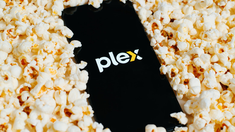 The Plex logo on a phone buried in popcorn