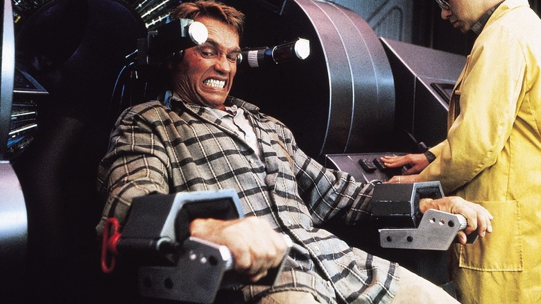 Quaid struggling as strapped in a metal chair