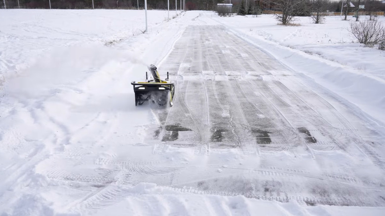 A Yarbo snow blower clearing a long driveway