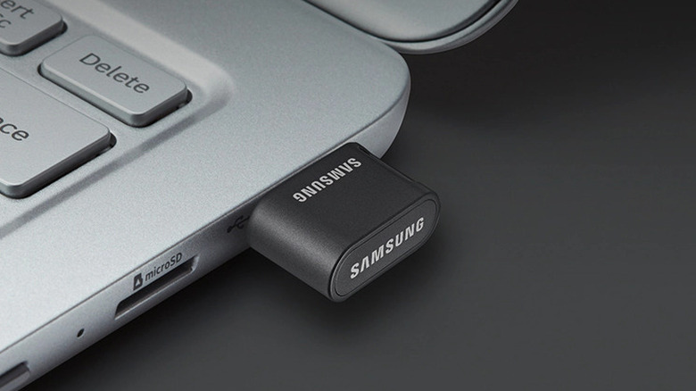 A black Samsung USB flash drive plugged into a laptop