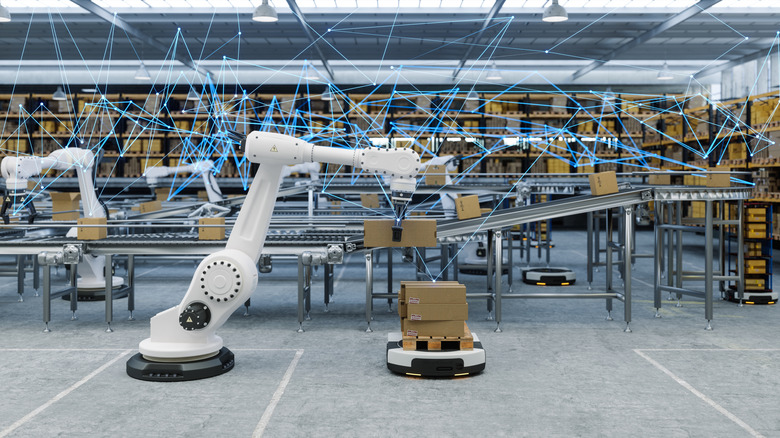 Robotic arms picking up boxes from a conveyor belt.