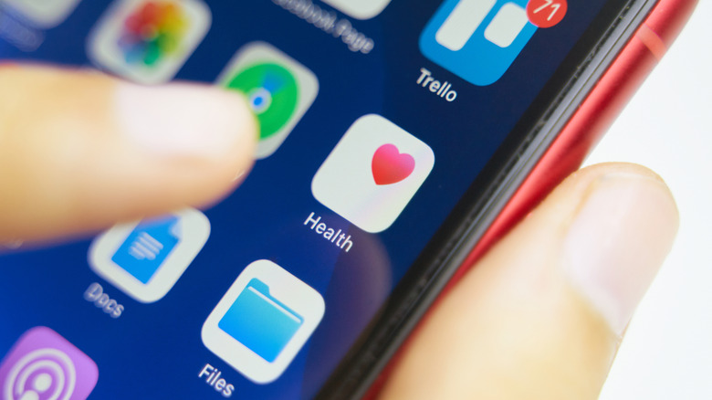 A person tapping the Health app on an iPhone.