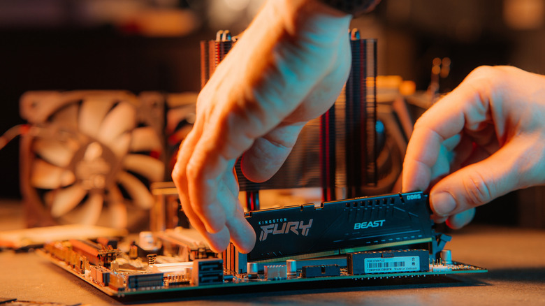 A PC builder installing RAM into a motherboard.