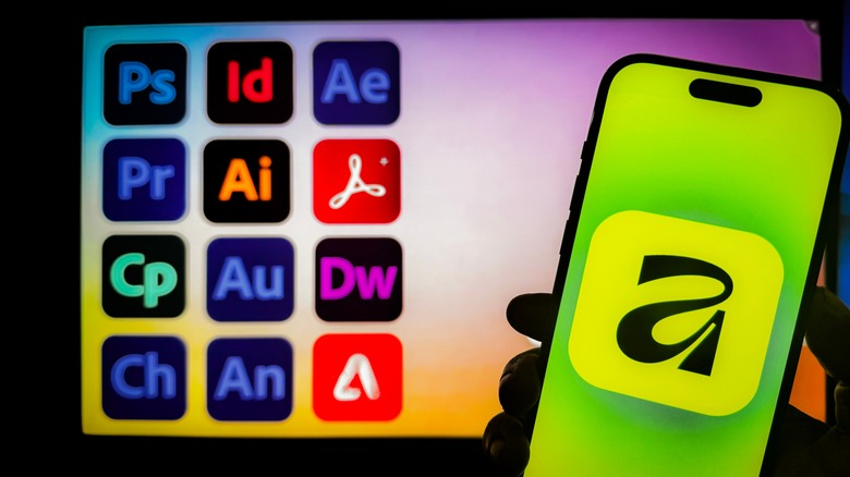 A person holds a smartphone displaying the Affinity app logo, set against a blurred background showing various Adobe Creative Cloud application icons.