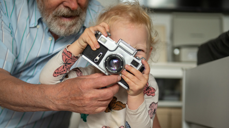 A child looks through the viewfinder of a camera