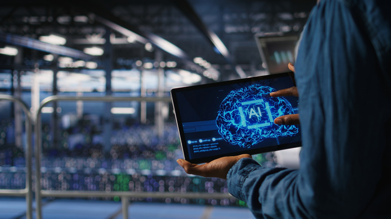 Worker using a tablet to control an AI data center.