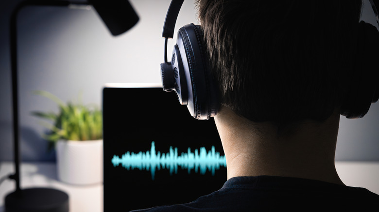A person listening to music while watching audio waveforms