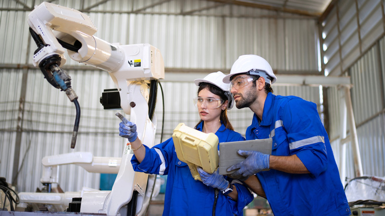 Blue-collar workers working alongside automated robotics