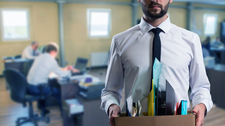 A white-collar worker carrying out his belongings after a layoff
