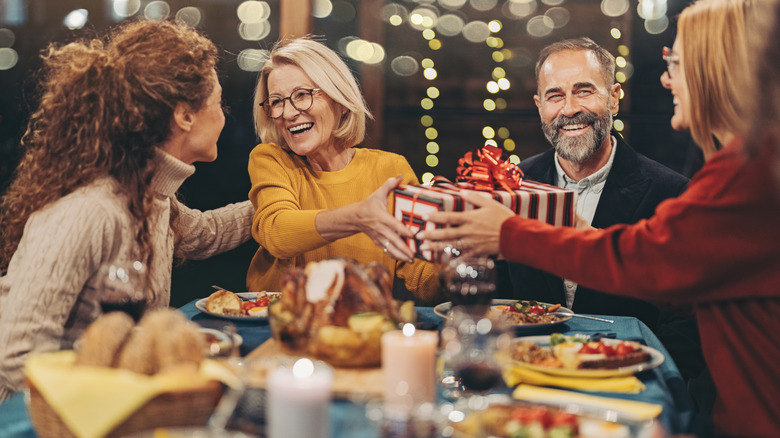 People at a holiday party eating and exchanging gifts