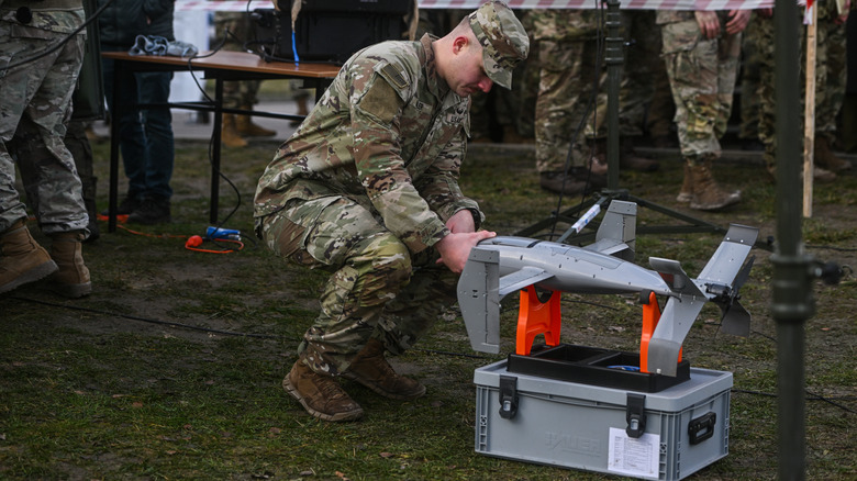 A soldier is pictured setting up an AI drone.